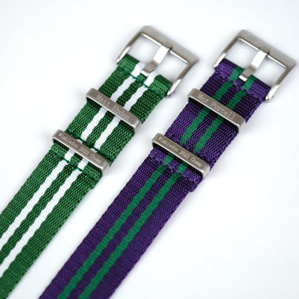 Close-up of green and purple ballistic nylon straps with stainless steel buckles and engraved names, Matt Ebden and Max Purcell, against a white backdrop - Under the Cuff's Ballistic Strap Collection